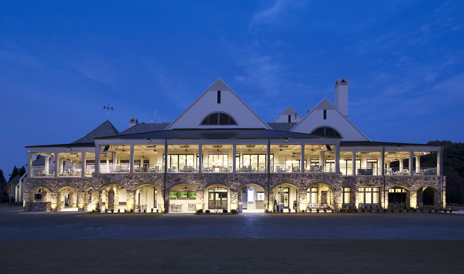 view of the Cherokee Country Club clubhouse and veranda at dusk